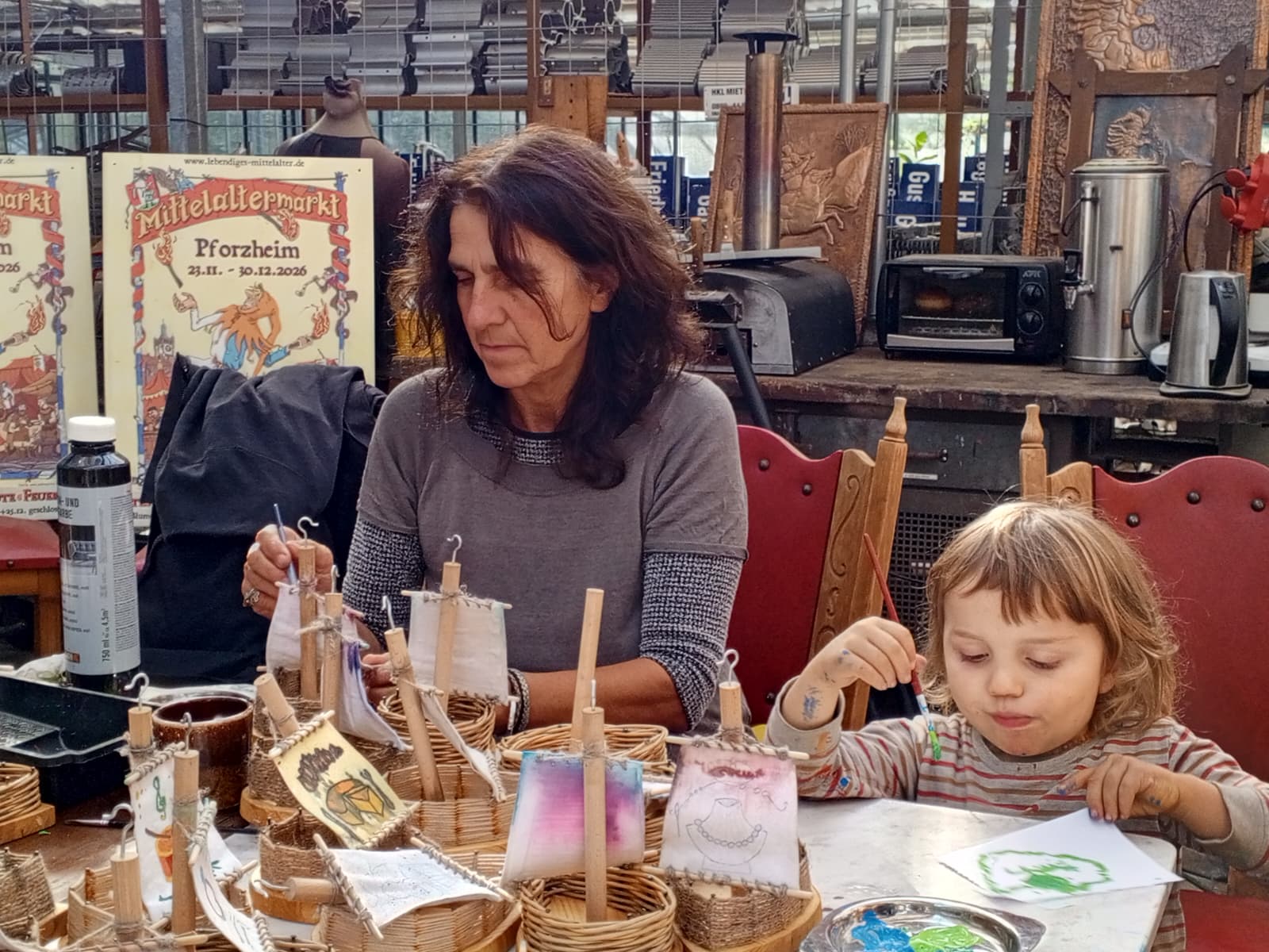 Frau und Kind beim Bemalen selbst gestalteter Dekorationen